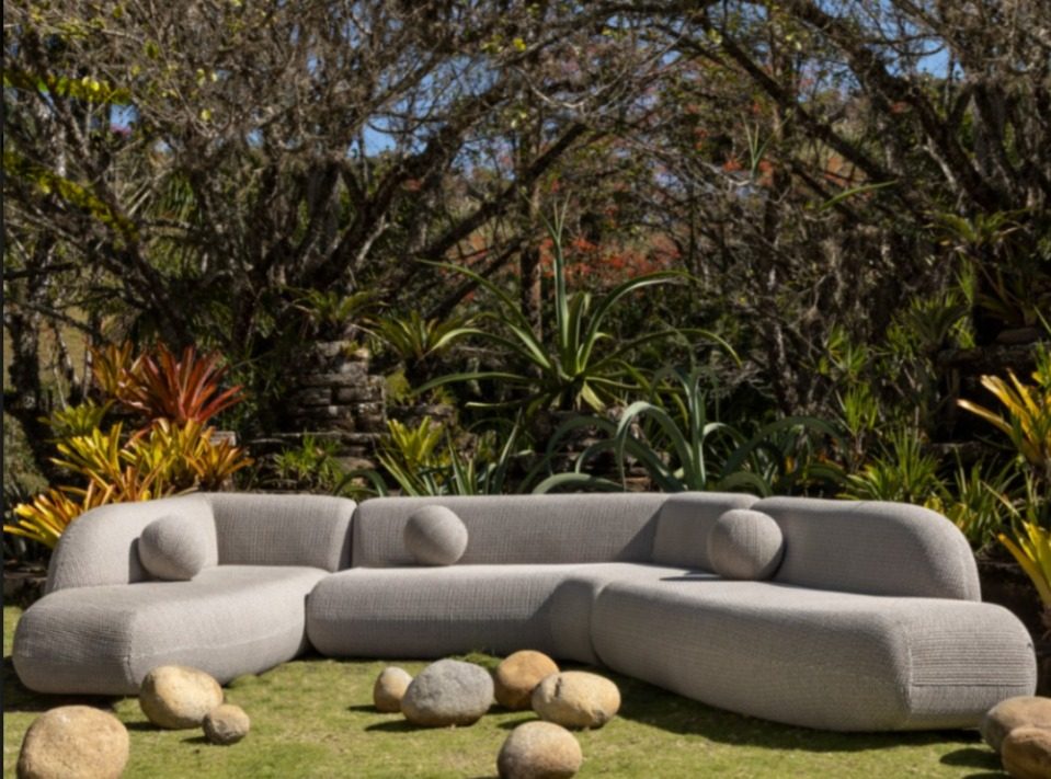 Sofá orgânico cinza em jardim tropical